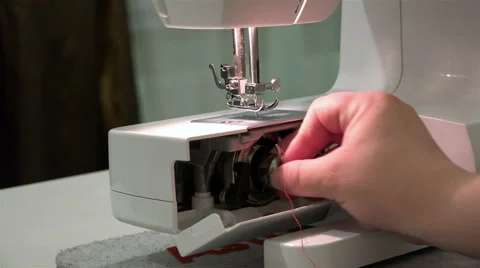 Female hand inserts the bobbin case with the pin in the needle plate Stock Footage 67843824