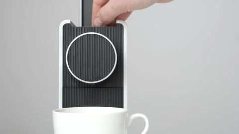 Female hand inserts a capsule into a coffee machine on gray background. Stock Footage 269321862