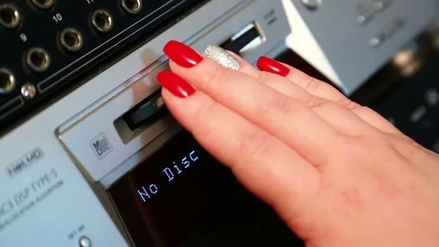 A female hand inserts a mini disc into a silvery player Stock Footage 84665514