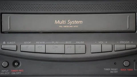 Female hand inserts an old VHS tape into a nostalgic VHS player Stock Footage 130463517