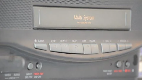 Female hand inserts an old VHS tape into a nostalgic VHS player Stock Footage 130463523