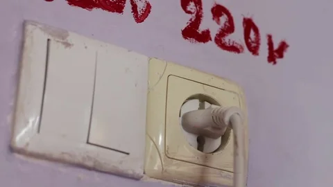 Female hand inserts a plug into a 220 volt socket Stock Footage 80960190