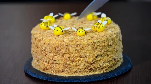 Female hand with a knife cuts fresh homemade honey cake Stock Footage