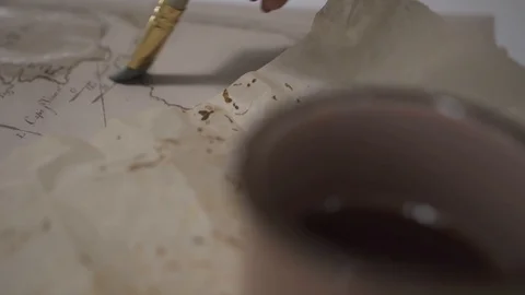 Female hand make aged map with paint brush and transparent watercolor, close-up Video stock 94761906