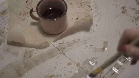 Female hand make aged map with paint brush and transparent watercolor, close-up Stock-Footage 94765613