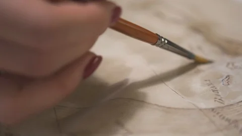 Female hand make aged map with paint brush and transparent watercolor, close-up Stock-Footage 94766694
