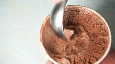 Female hand making a chocolate bites ice cream ball with metal spoon 4K close up Stock Footage 156205968