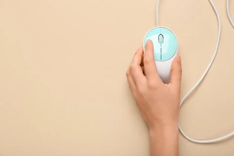 Female hand with modern computer mouse on beige background Stock Photos
