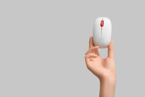 Female hand with modern wireless computer mouse on grey background Stock Photos
