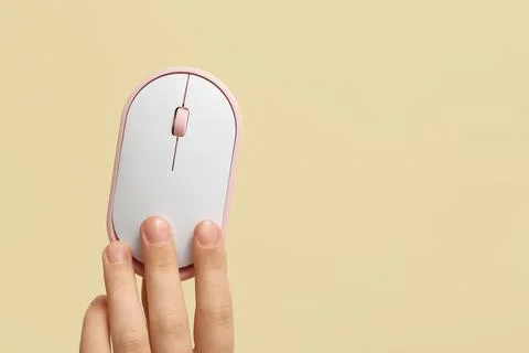 Female hand with modern wireless computer mouse on beige background Stock Photos