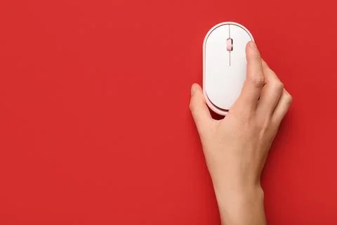 Female hand with modern wireless computer mouse on red background Stock Photos