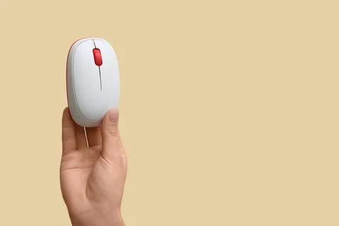 Female hand with modern wireless computer mouse on beige background Stock Photos