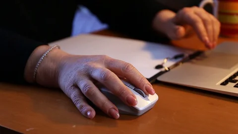 Female hand moves a wireless computer mouse working on a notebook on a desk Stock Footage 128128924