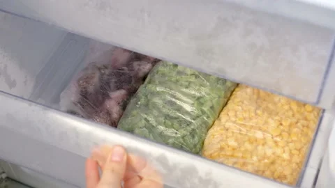 Female hand opens a box with packages of frozen vegetables in the refrigerator Stock Footage 234961207