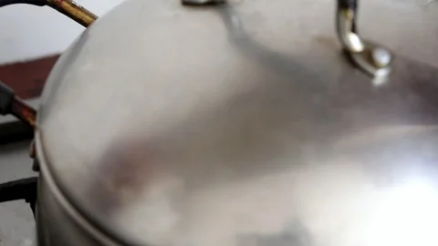 The female hand opens the lid on the pan and stirs the boiling soup with the Stock Footage 92331032