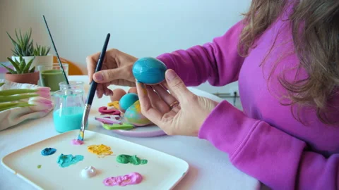 Female hand painted Easter eggs, paints and brushes. Preparation for the holiday Stock Footage 151354874