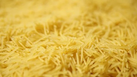 Female hand picks dry thin short noodles for cooking. Yellow noodle backgroun Stock Footage 110791166