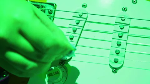 Female hand picks guitar strings with a pick. Concert lighting. Stock Footage 96260019