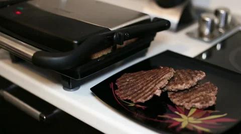 Female hand picks up a light bread on an electric grill and lays down on a plate Stock Footage 60573671