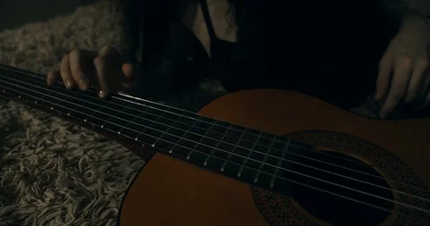 Female hand playing a guitar string. Handheld. Stock Footage 123914133