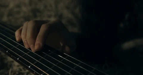 Female hand playing a guitar string. Close-up handheld. Stock Footage 123914232
