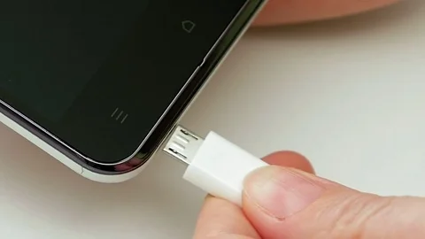 Female hand plugging charger cell phone smartphone Stock Footage 69970583