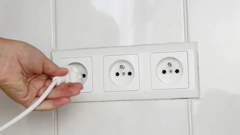Female hand plugging an electrical power plug into a wall socket. 스톡 동영상 339006781
