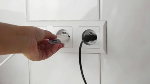 Female hand plugging an electrical power plug into a wall socket. 스톡 동영상 339006783
