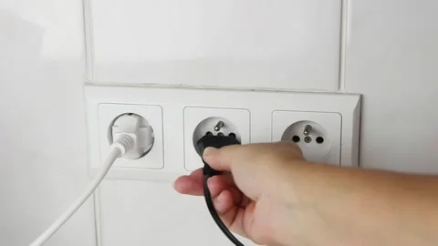 Female hand plugging an electrical power plug into a wall socket. 스톡 동영상 339006784