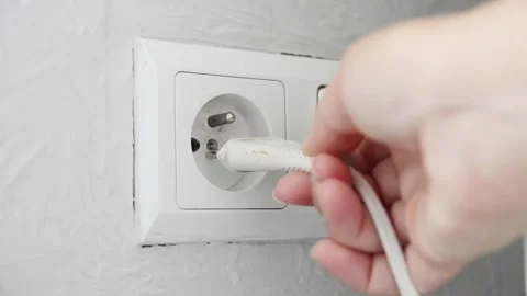 Female hand plugging an electrical power plug into a wall socket. 스톡 동영상 339006864