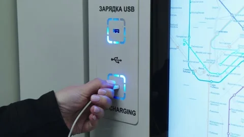 Female hand is plugging the usb cable to the free charging port with russian and Stock Footage 202049184