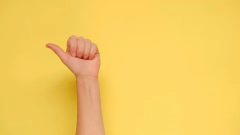Female hand pointing on copyspace isolated over yellow background Stock Footage 116675027