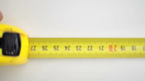 Female Hand Presses Button of an Orange Metallic Tape Measure with a Return Stock Footage 227029900