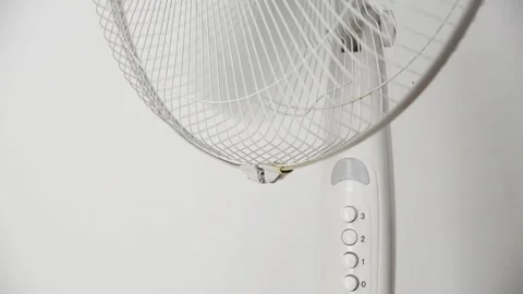 Female hand presses the power button to switch on an electric pedestal fan 動画素材 339005227