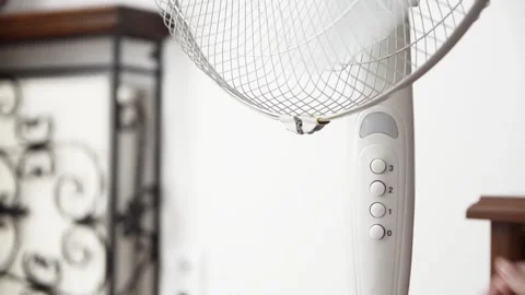 Female hand presses the power button to switch on an electric pedestal fan 스톡 동영상 339005228