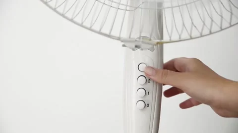Female hand presses the power button to switch on an electric pedestal fan 스톡 동영상 339005230