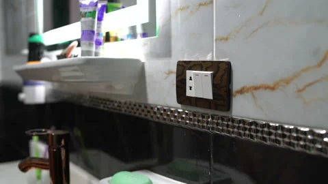 Female hand presses the switch button and the light goes out at the mirror Stock Footage 101481538