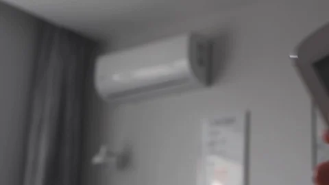 Female hand pressing a button on and off the air conditioner Stock Footage 108591529
