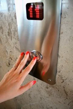 Female hand pressing elevator up button Foto stock