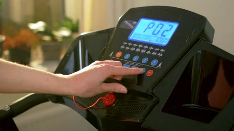 Female hand pressing treadmill control panel while selecting cardio training Stock Footage 333245947