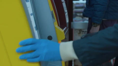 Female hand in protective gloves inserting a card into an ATM Stock Footage 141337360