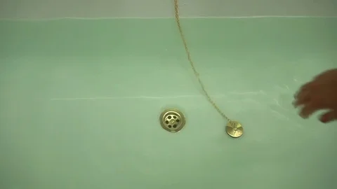 Female hand pull off chain with bath tub drain stopper from bath  스톡 동영상 80007376