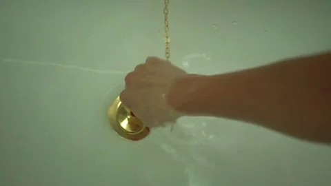 Female hand pull off chain with bath tub drain stopper from bath  스톡 동영상 80007532