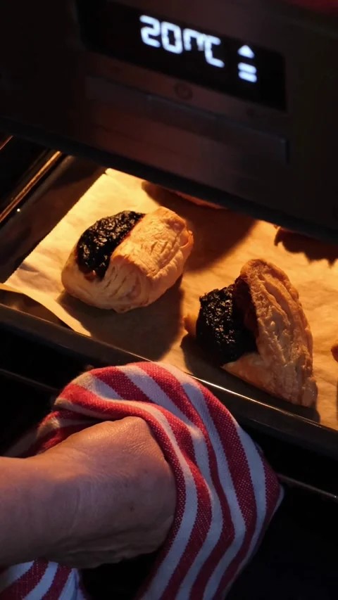 Female hand pulling out a baking tray full of freshly baked Leaf Fat Pastry Stock Footage 270555605