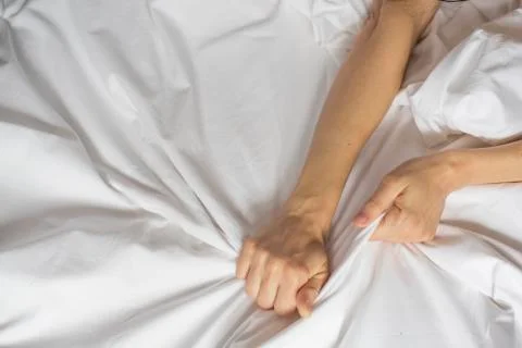 Female hand pulling white sheets in ecstasy, orgasm. Foto stock
