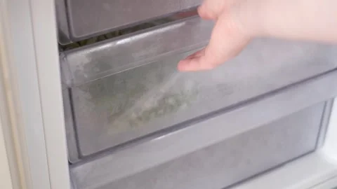 Female hand pulls out drawer in refrigerator with packages of frozen food. Stock Footage 266071894