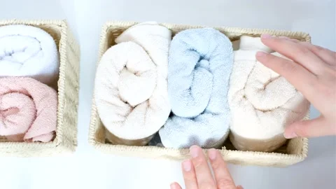 Female hand pulls out a rolled towel from wicker box, space organization concept Stock Footage 196577563
