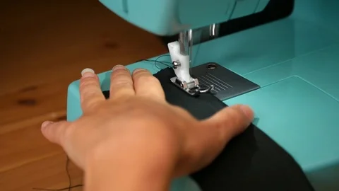 A female hand pushes material through a sewing machine Stock Footage 112186039