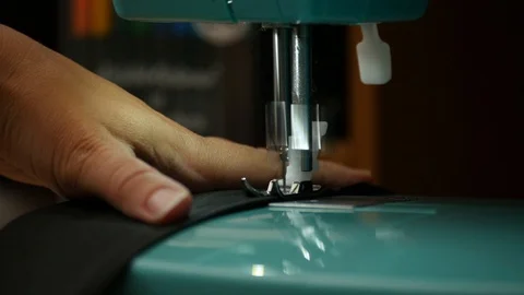 A female hand pushes material through a sewing machine Stock Footage 112186059