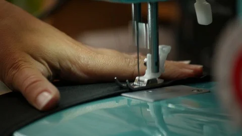 A female hand pushes material through a sewing machine Stock Footage 112186079